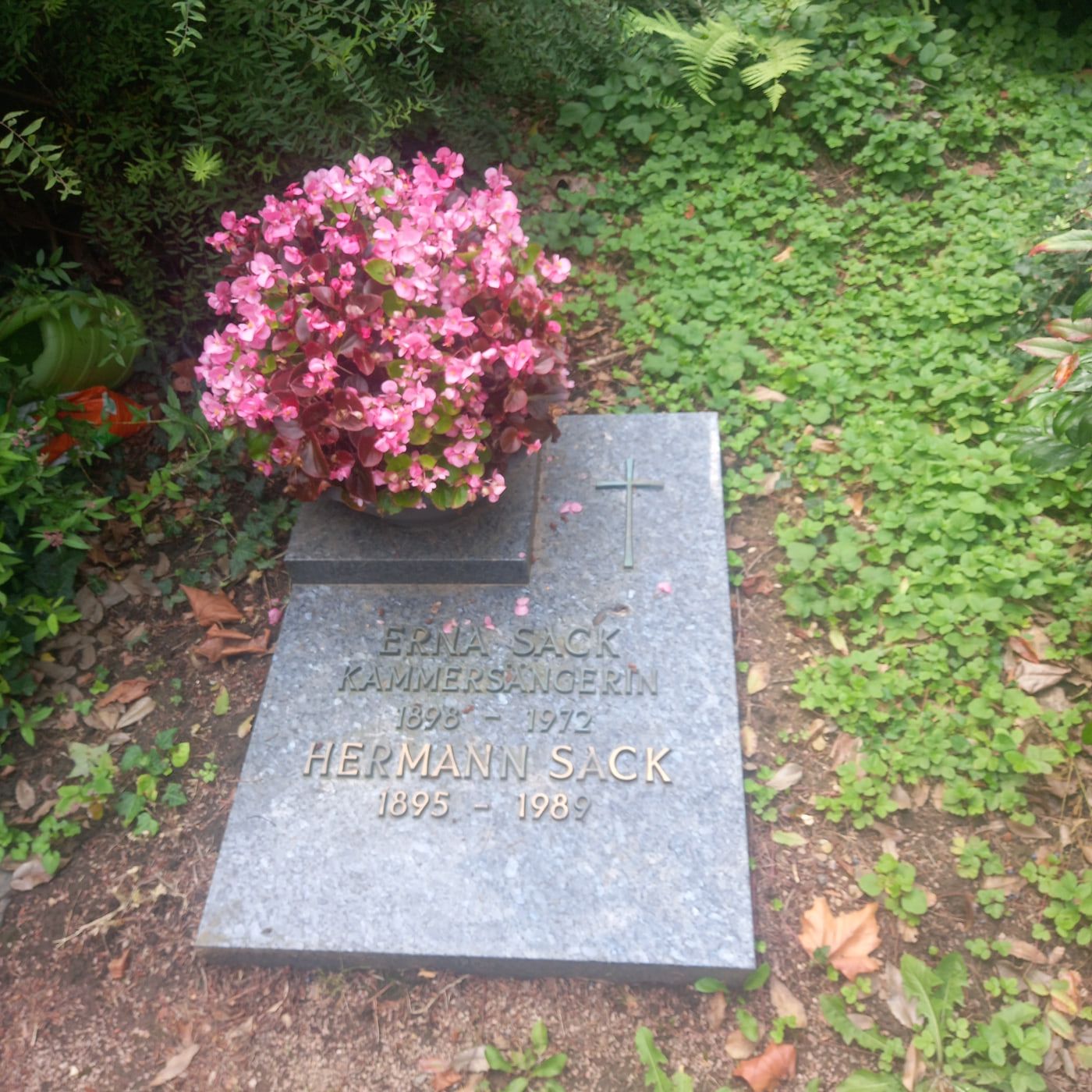 Flache graue Grabplatte für Erna und Hermann Sack mit Kreuz und rosafarbenem Blumenschmuck auf Südfriedhof Wiesbaden